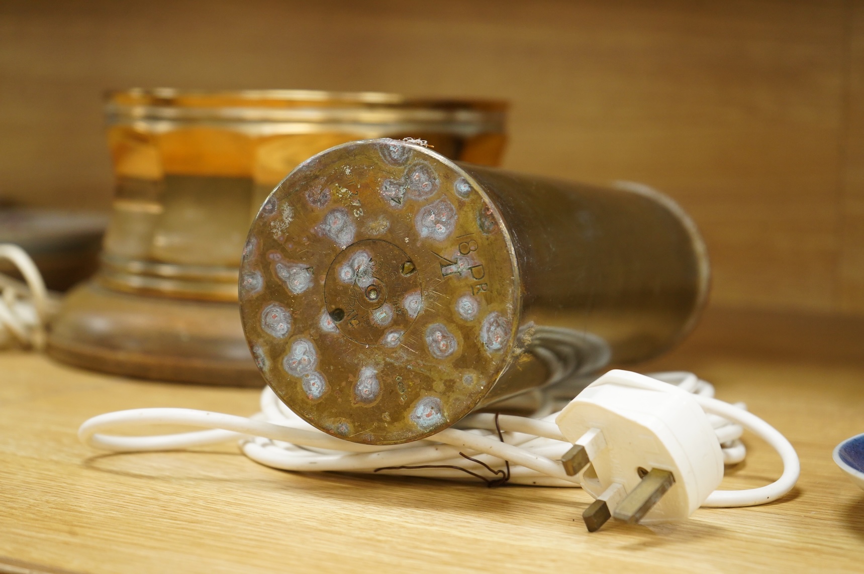 A bronze spitoon on plinth and a near pair of cartridge case table lamps, largest 46cm high